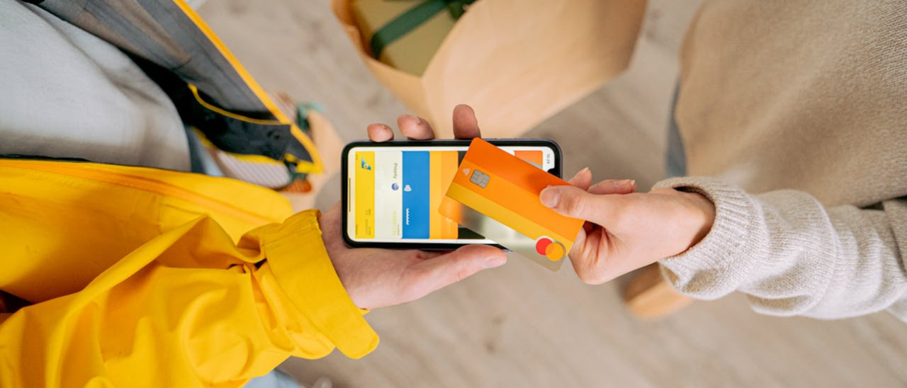 Pessoa pagando com cartão por aproximação no celular