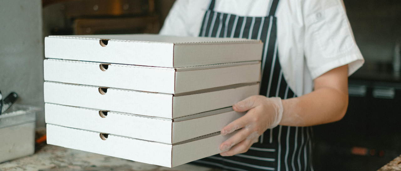 Pizzaiolo segurando caixas de pizza